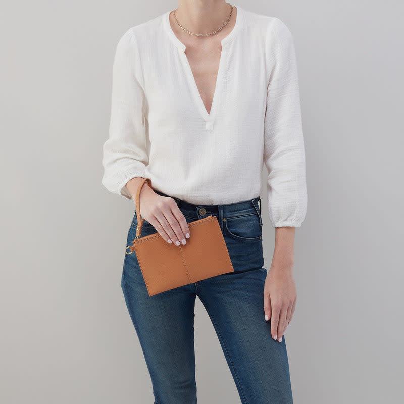 Biscuit-colored leather Vida small pouch with coconut shell interior, credit card slot, and brushed antique brass hardware.