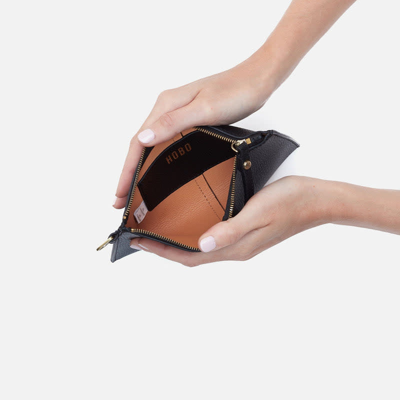 Black leather Vida small pouch with coconut shell interior, antique brass hardware, zip closure, and suede lining.
