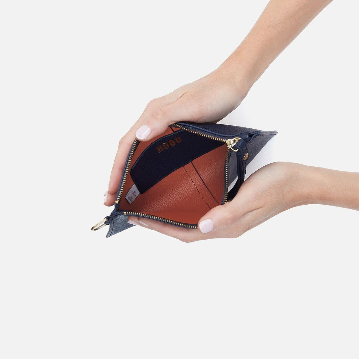Open indigo suede Vida small pouch with coconut shell interior, brass hardware, card slot, and leather strap.