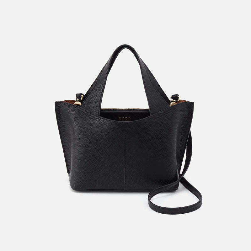 Black leather small tote bag with brushed antique brass hardware, biscuit interior lining, and removable adjustable strap.