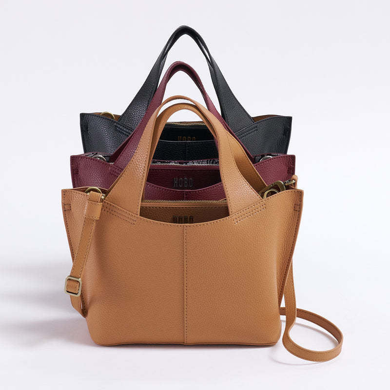 Small tote bag in biscuit leather with brushed antique brass hardware.