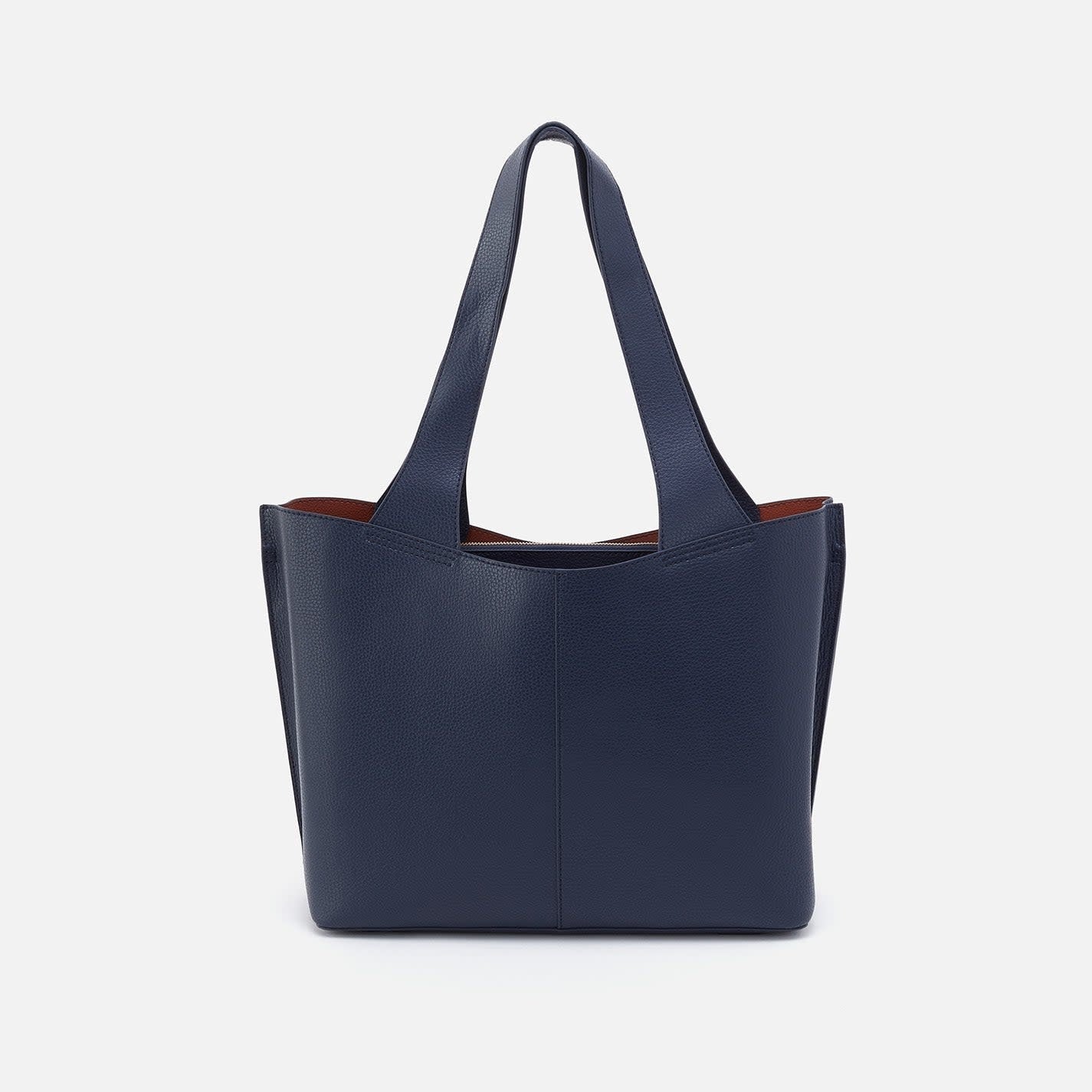 Indigo Vida tote bag with coconut shell interior lining, brass hardware, slip pockets, and double leather straps.