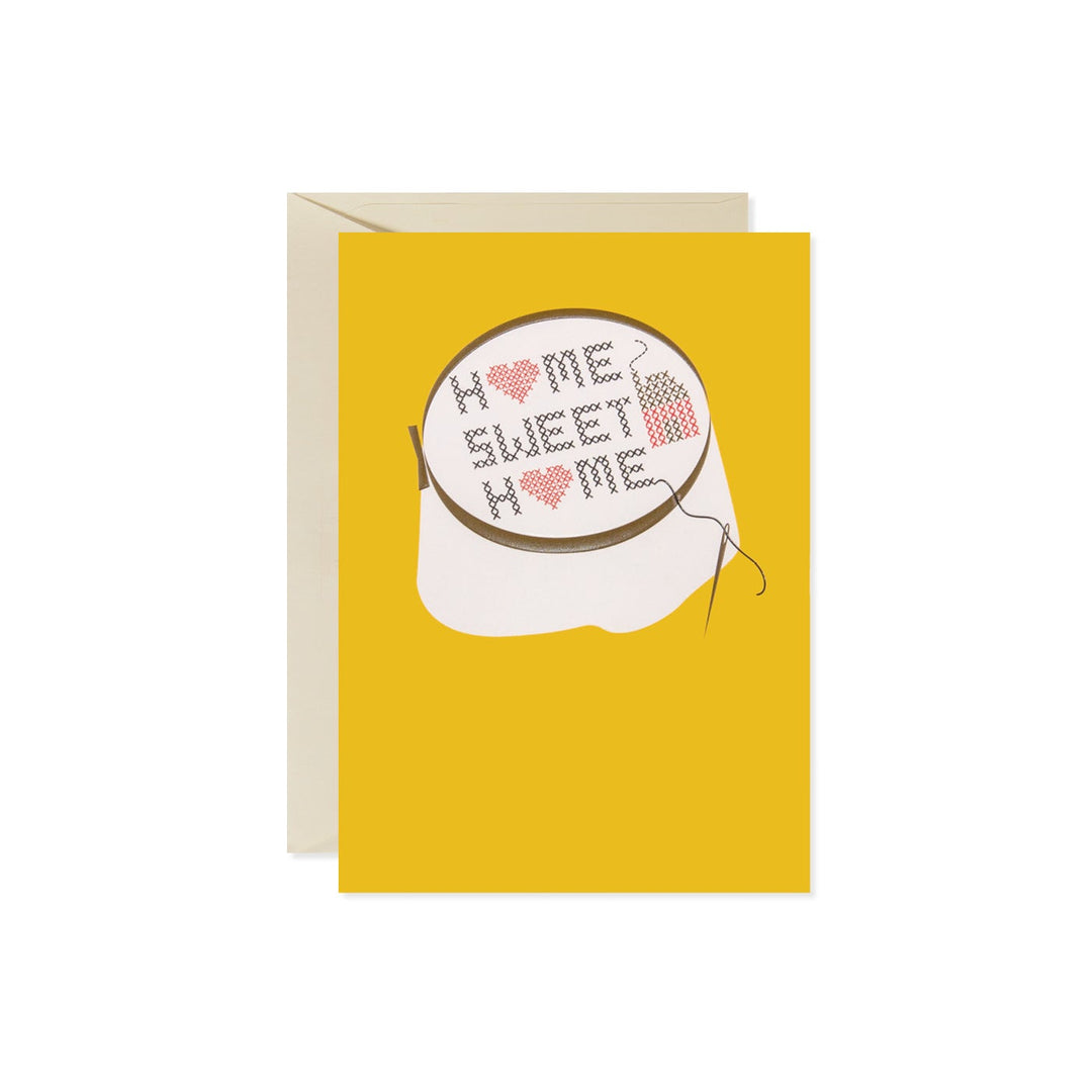 Yellow card with a cross-stitch hoop that says "HOME SWEET HOME" with red hearts.