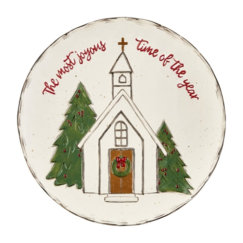 Round ceramic Christmas church platter with a festive red and green patterned rim.