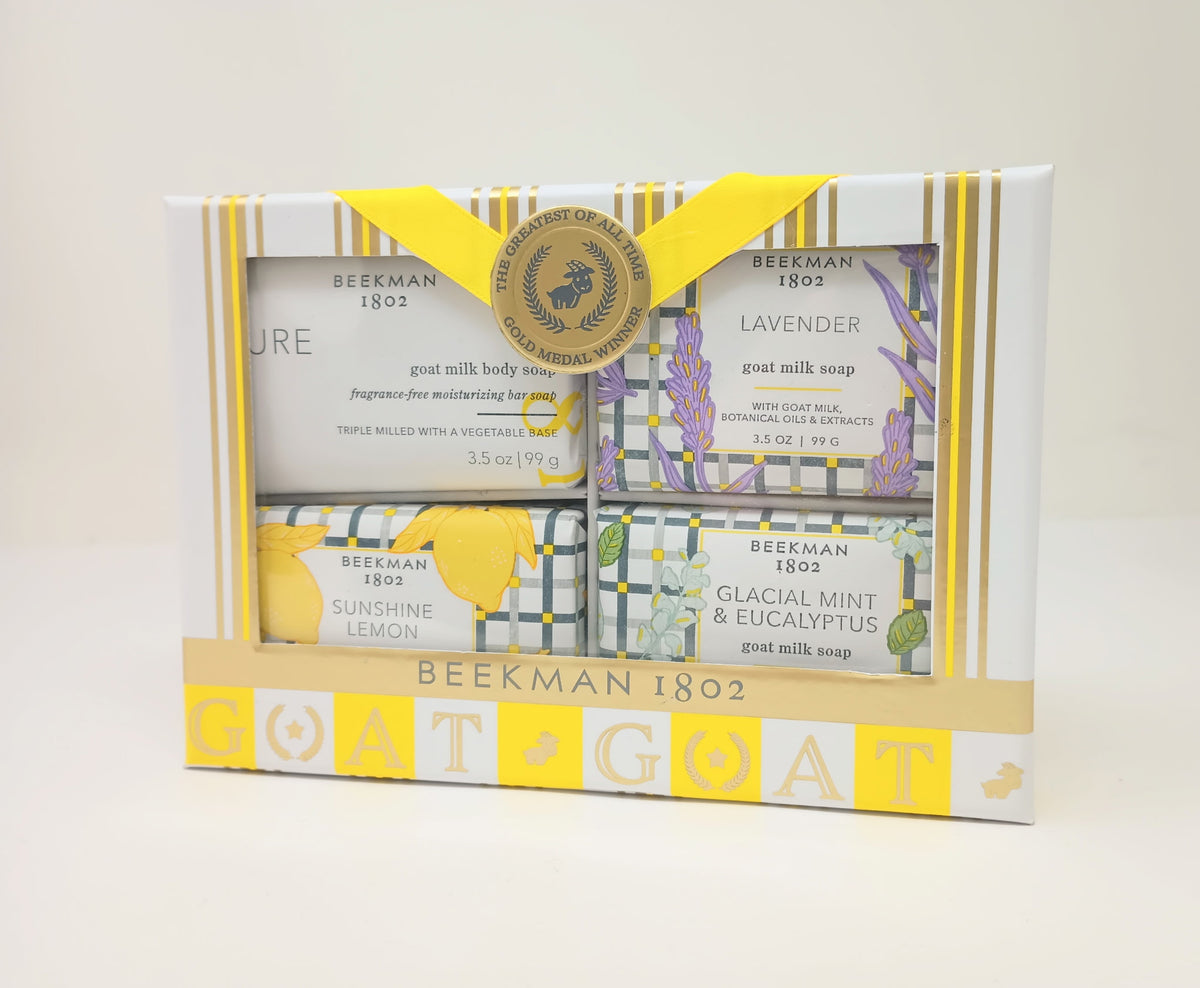 Set of four travel-sized goat milk bar soaps in lavender, lemon, mint, and eucalyptus scents.