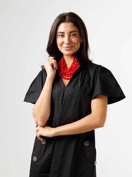 Woman wearing the black Gretchen Dress with a stand collar, pleated sleeves, and button pockets.