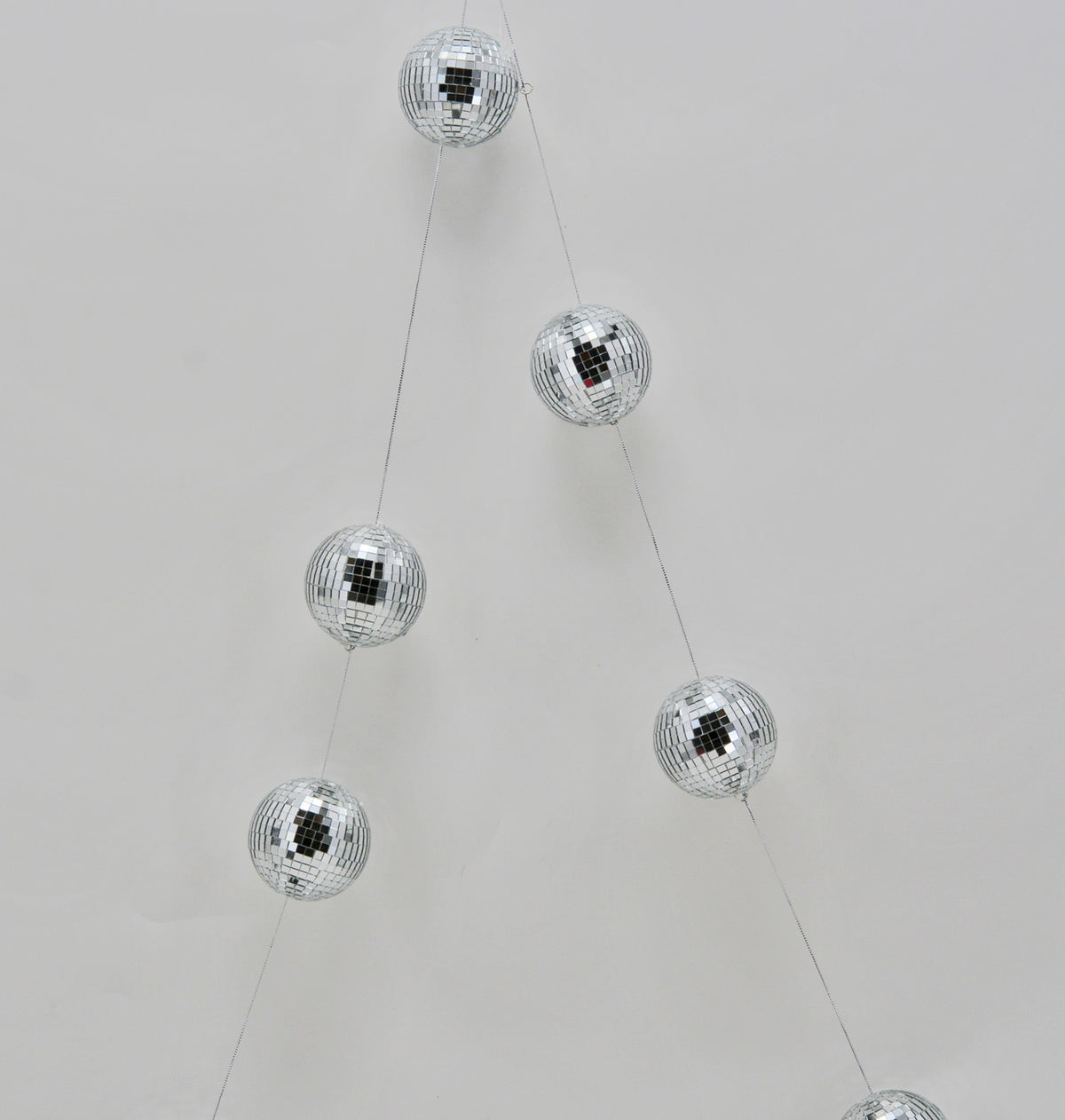 Silver disco ball Christmas ornament garland hanging against a white background.