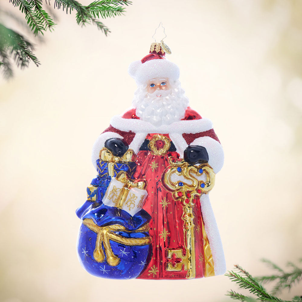 Glass Santa ornament with red coat, blue gift bag, and golden key.