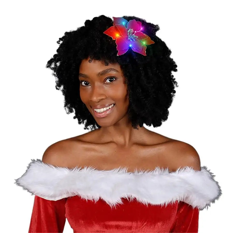 Woman wearing a light up red poinsettia hair clip with gold glitter and multi-colored LED lights.