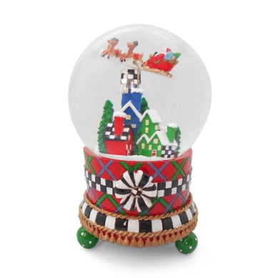 Tartan Village Snow Globe with Santa's sleigh flying over colorful houses on a patterned base.