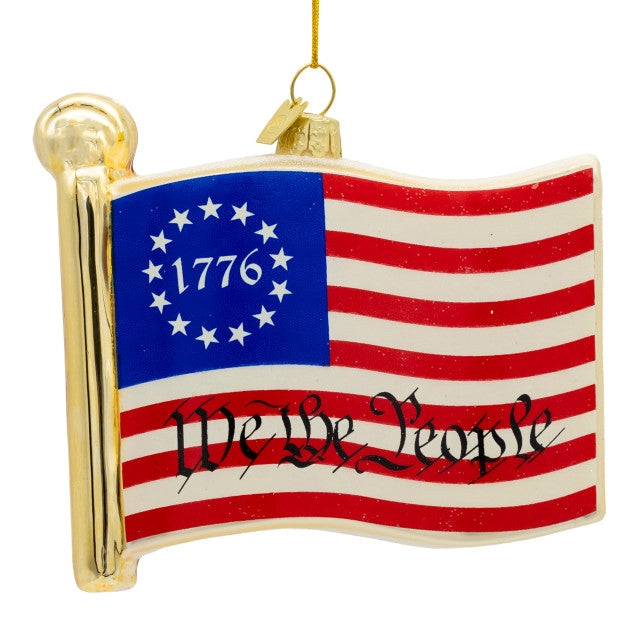 Glass American flag ornament with 1776 in a star circle and "We The People" script.