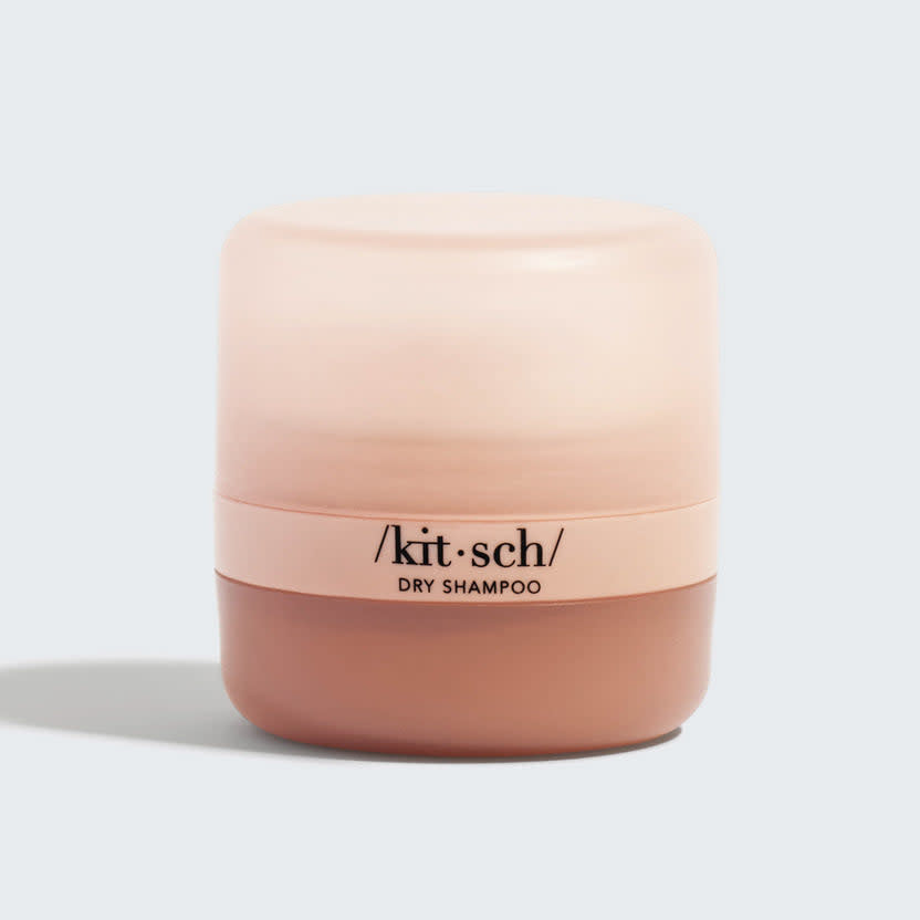 Volumizing rice protein dry shampoo powder in a recycled plastic container with built-in puff applicator.