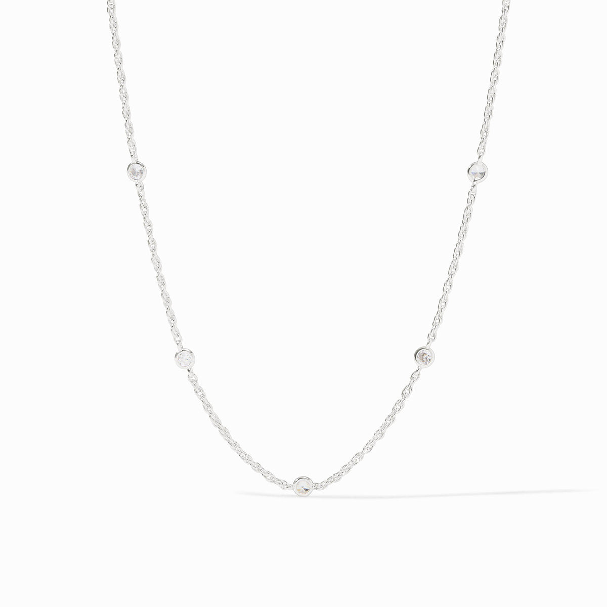 Silver station necklace with five bezel-set cubic zirconia stones on a delicate chain.