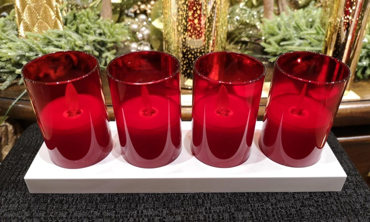 Set of rechargeable flameless votive candles with chargers in a warm glow.