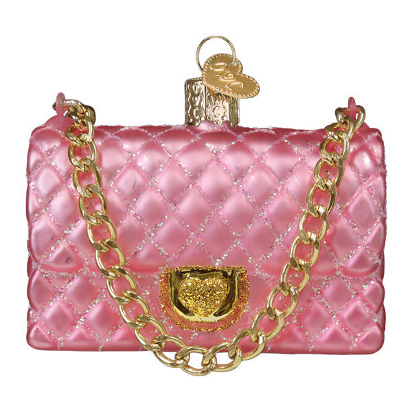 Pink quilted glass purse ornament with a gold chain strap and heart-shaped clasp.