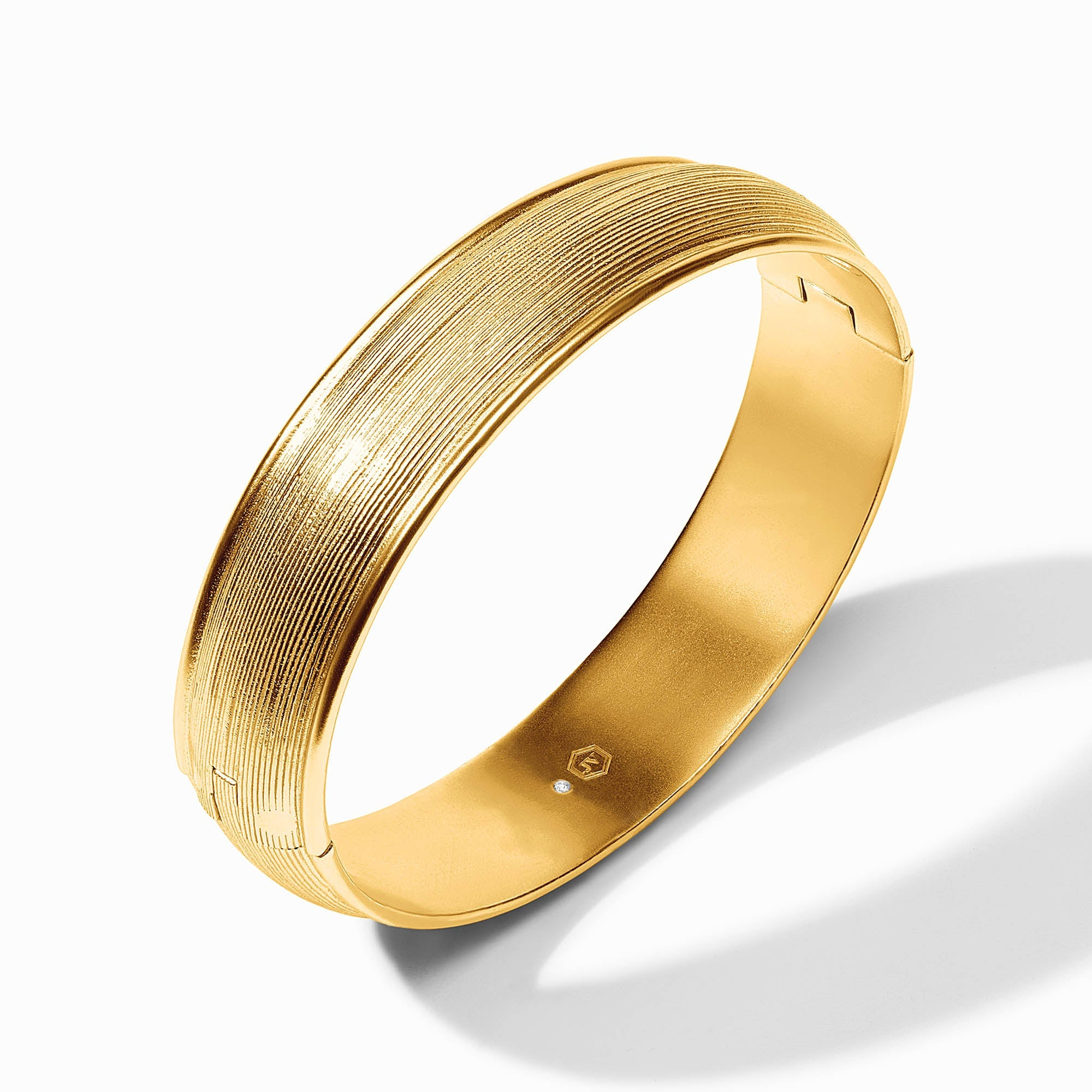 Gold-plated Cobblestone Hinge Bangle with a textured exterior and smooth interior hallmark.