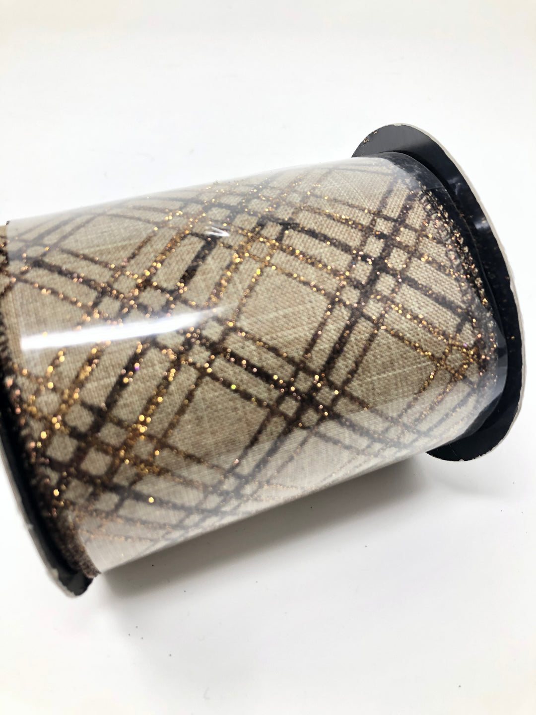 Spool of light natural linen ribbon with a copper brown glitter plaid criss-cross pattern.