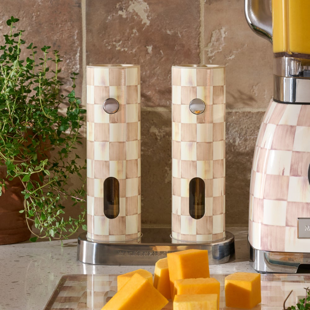 Mocha Check Electric Salt & Pepper Grinder Set on a charging base next to a blender and cheese.