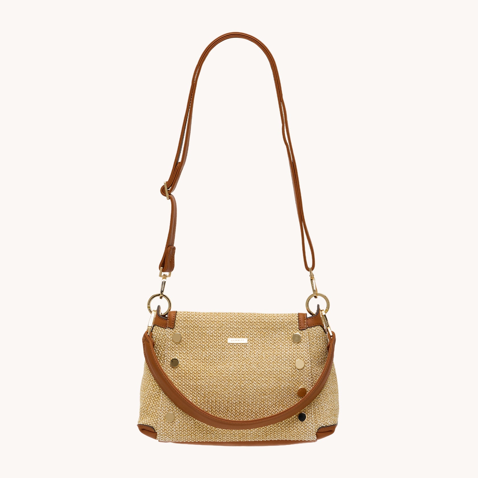 Bryant Med Cocoa Raffia crossbody bag with tan leather trim, gold studs, and adjustable strap.