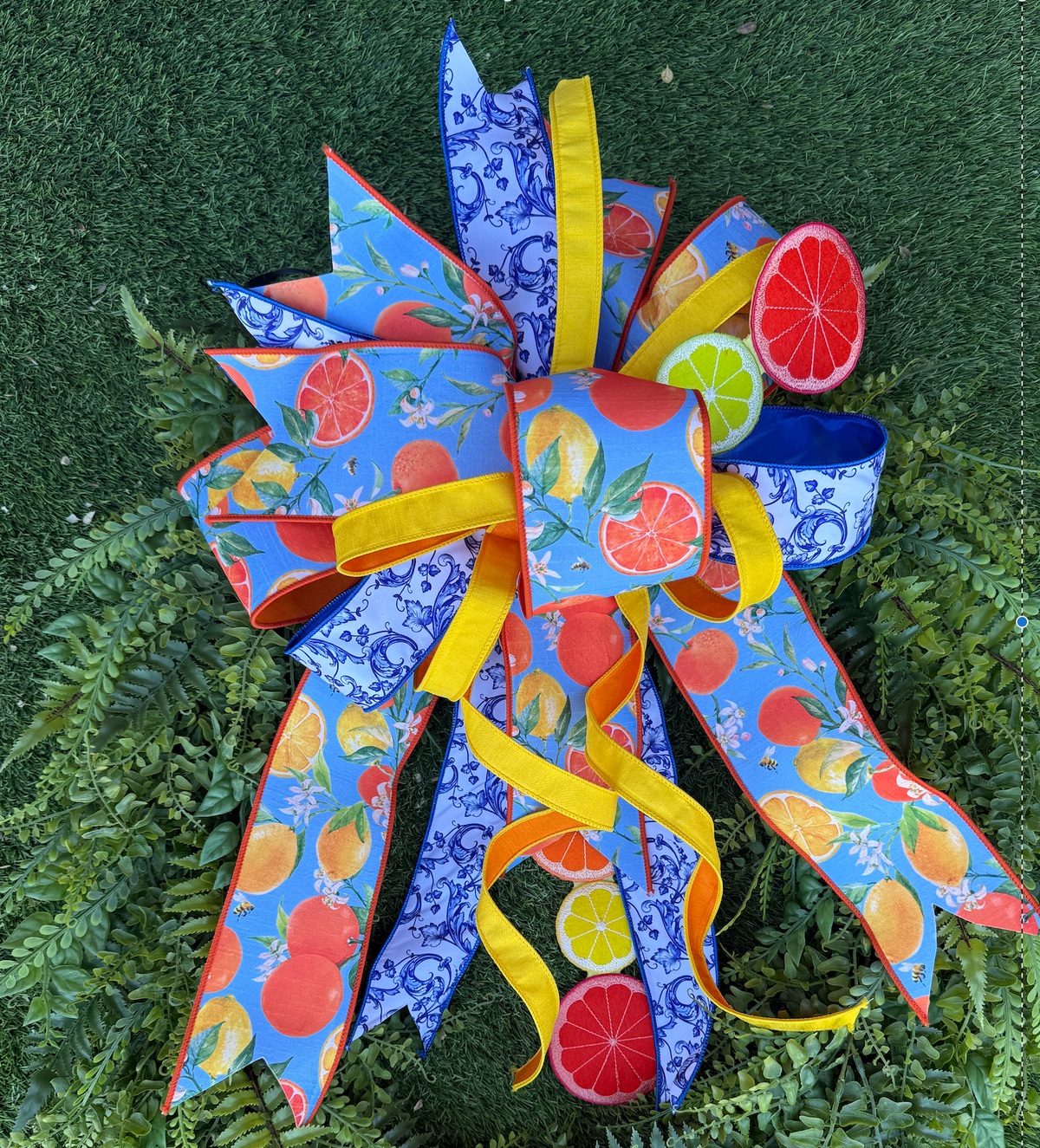 Blue Citrus Bow hair accessory featuring a citrus fruit print on blue fabric with an adjustable elastic band.