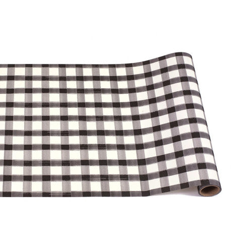 A roll of black and white painted check paper table runner partially unrolled.