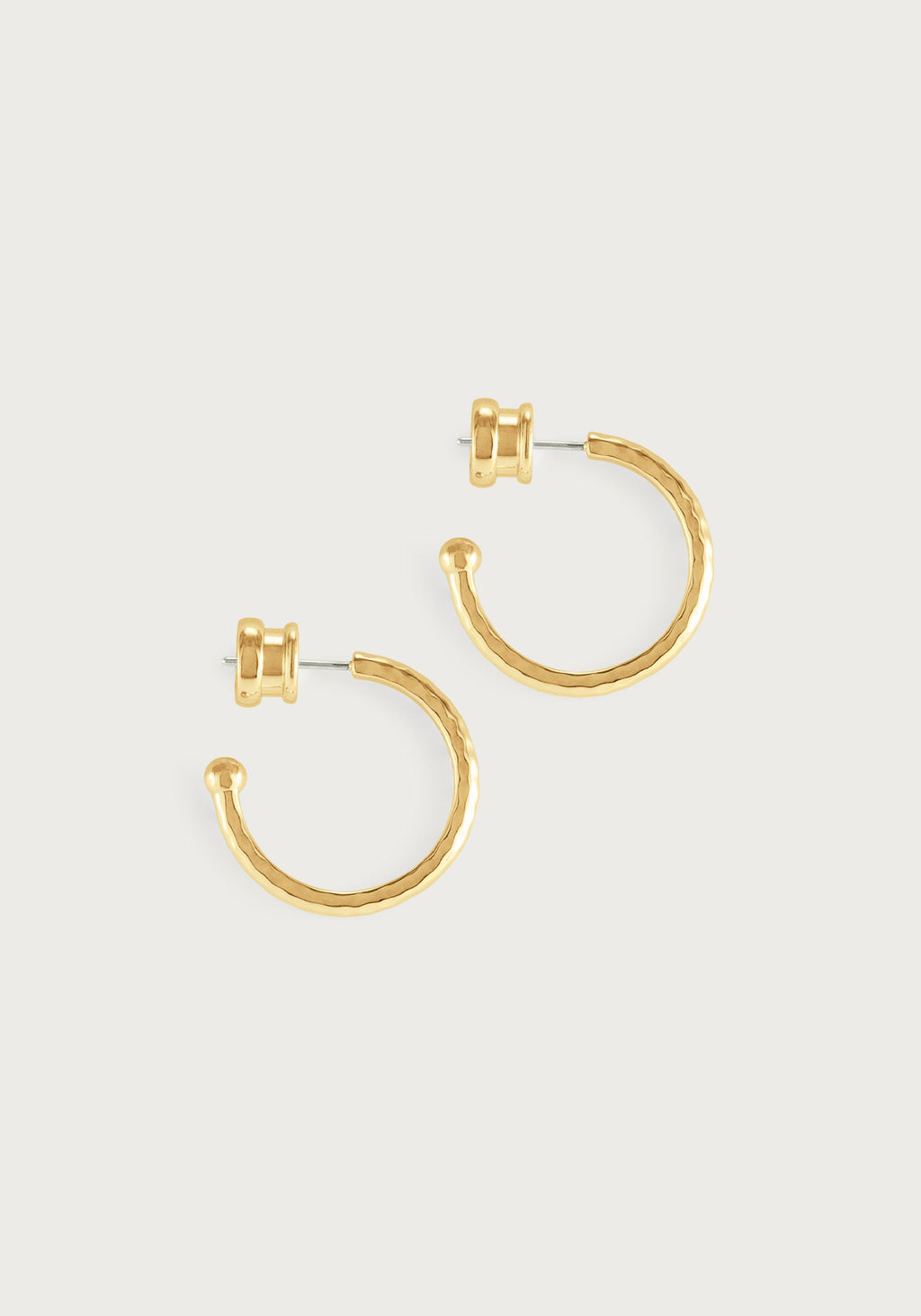 A pair of medium gold Farrier Charm Hoop earrings with a hammered texture and ball ends.