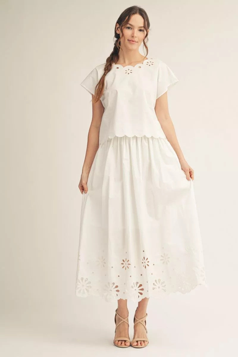 Woman wearing the Sarah white cotton eyelet midi skirt with a scallop hem and matching top.