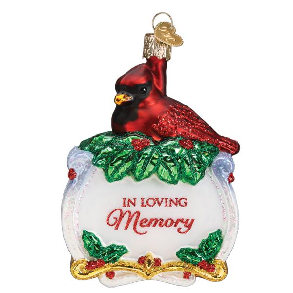Glass memorial cardinal ornament with 'In Loving Memory' text on a white base with holly leaves.