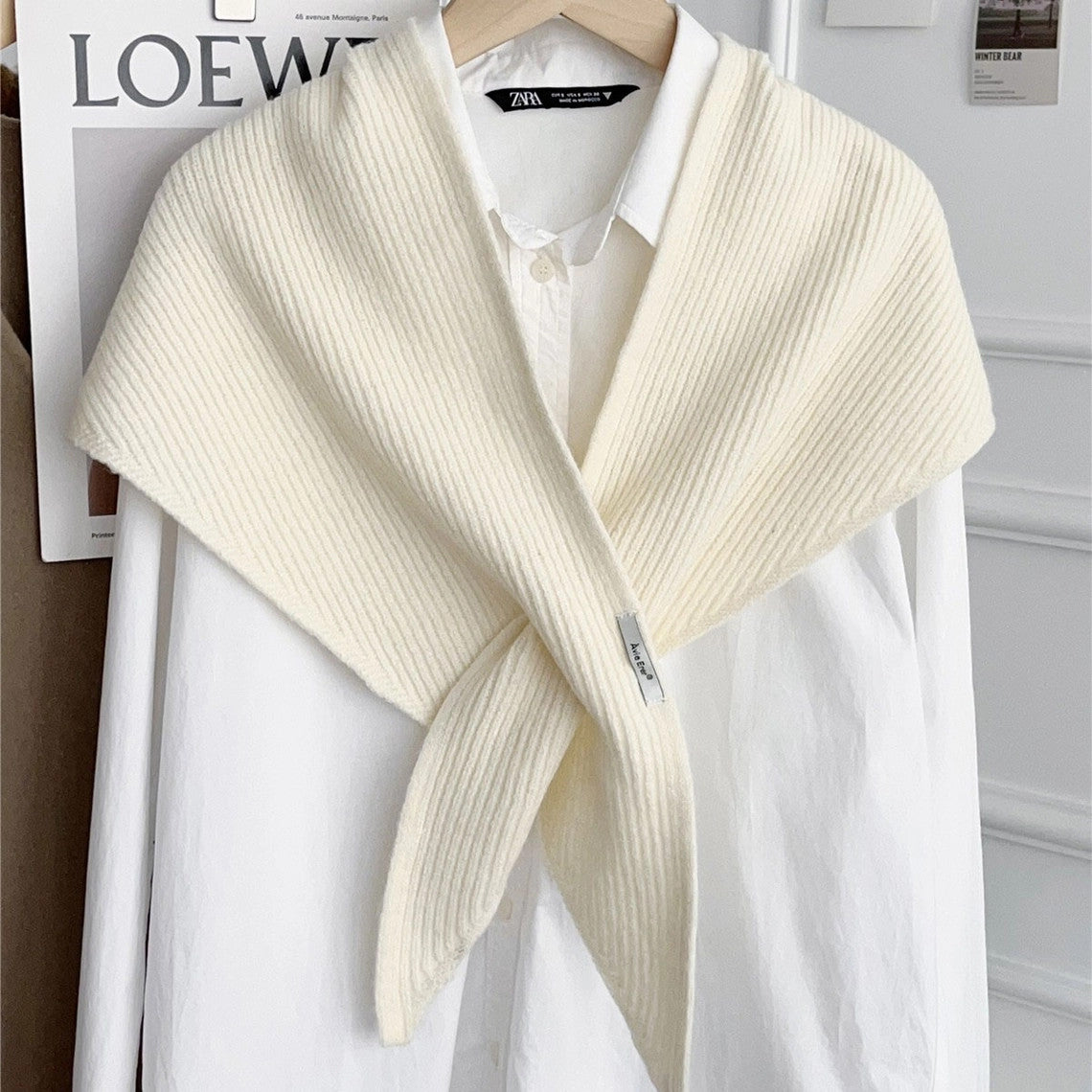 Cream-colored knitted solid cross triangle shawl draped over a white button-down shirt.