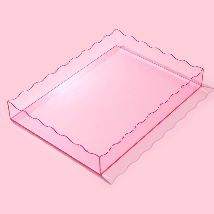 Large pink translucent acrylic rectangular tray with wavy scalloped edges.