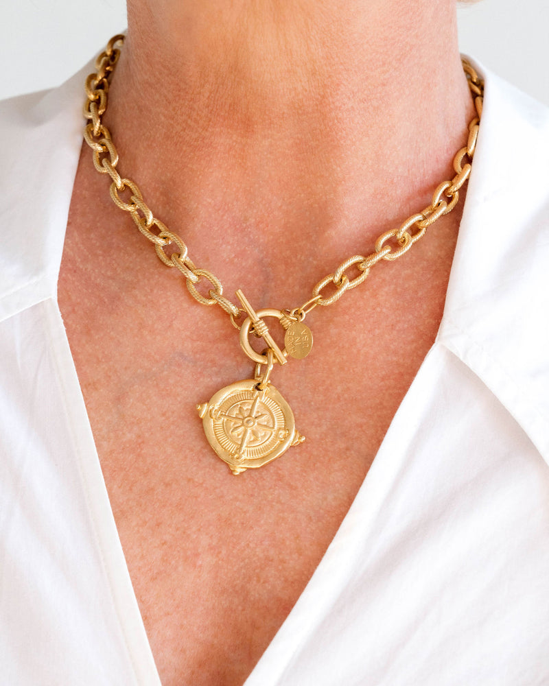 Handcast 24k gold-plated chain necklace with a compass pendant and front toggle clasp.