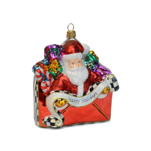 Glass Christmas ornament featuring Santa Claus popping out of a red envelope with gifts and a scroll.