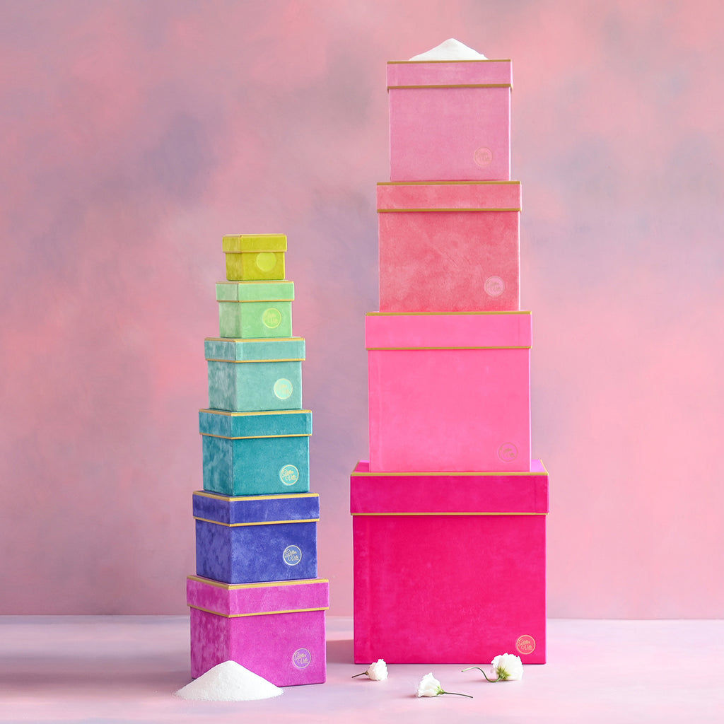 Square cardboard stacking box with flocked paper interior and gold-edged trim.