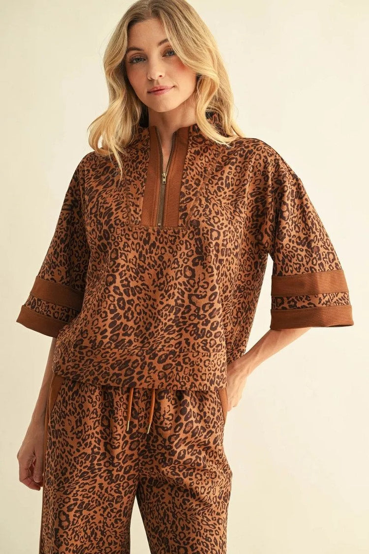 Woman wearing the Andy leopard print faux suede top with a quarter-zip and matching pants.