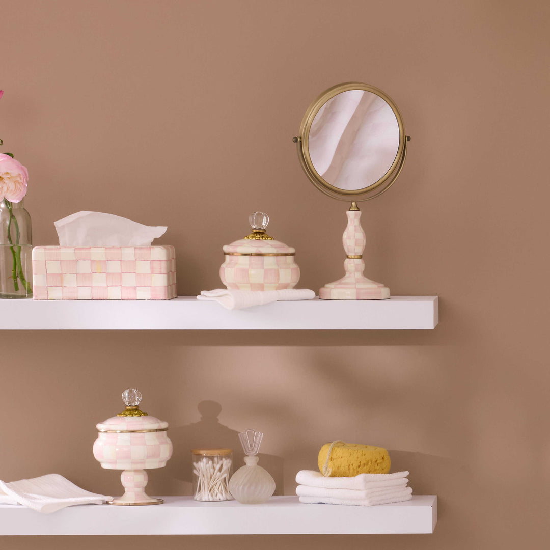 Hand-painted pink and white checkered tissue box cover on a white shelf with bathroom accessories.