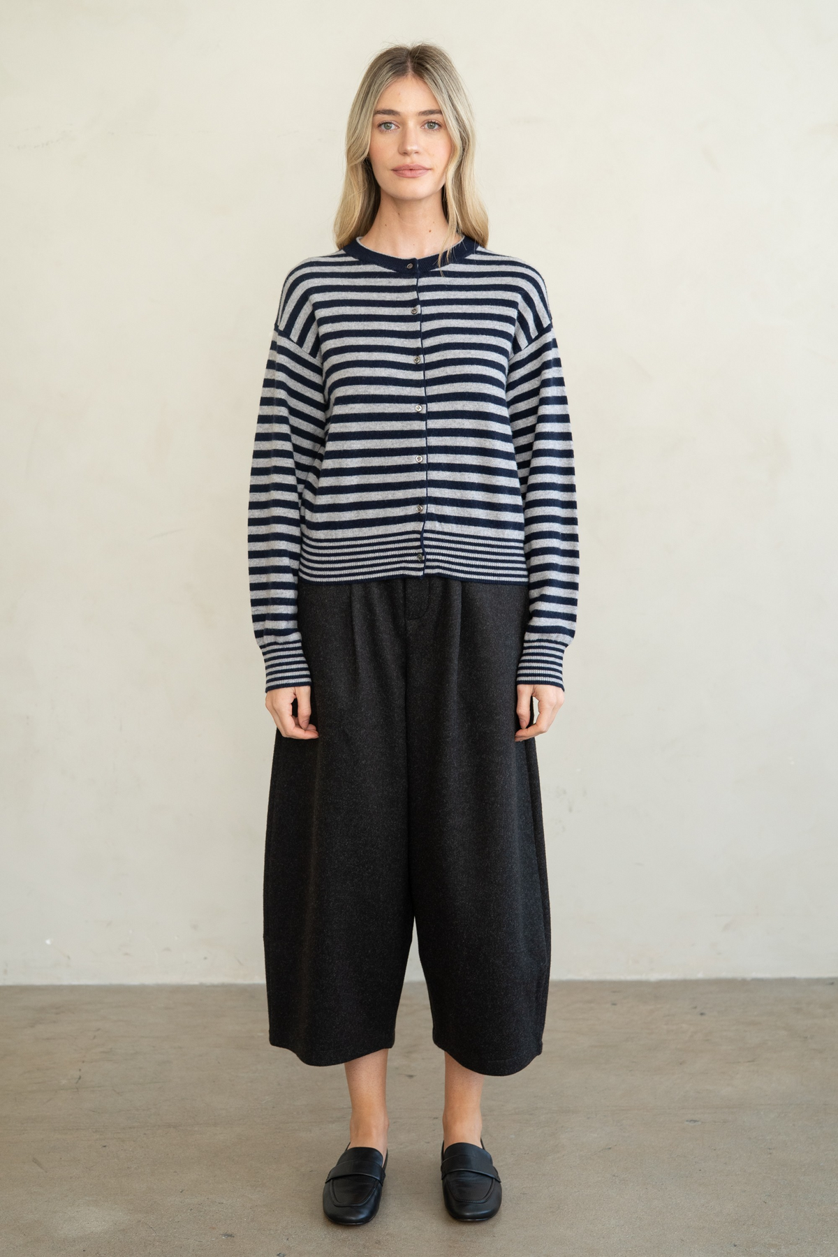 Woman wearing the Marian Striped Button Front Cardigan in grey and navy with wide-leg black pants.