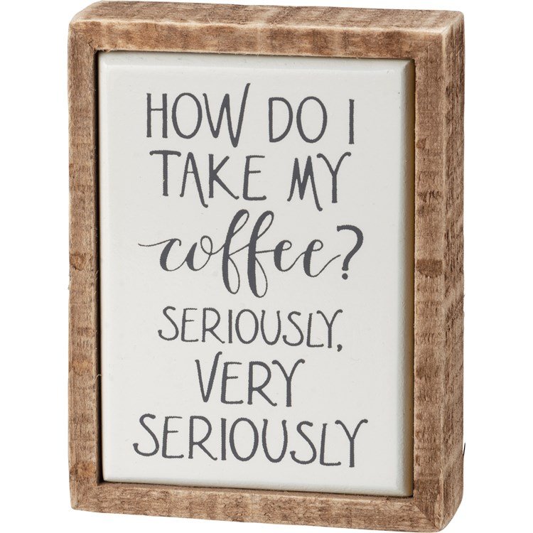 Wooden box sign with white background and black text that reads 'HOW DO I TAKE MY COFFEE? SERIOUSLY, VERY SERIOUSLY.'
