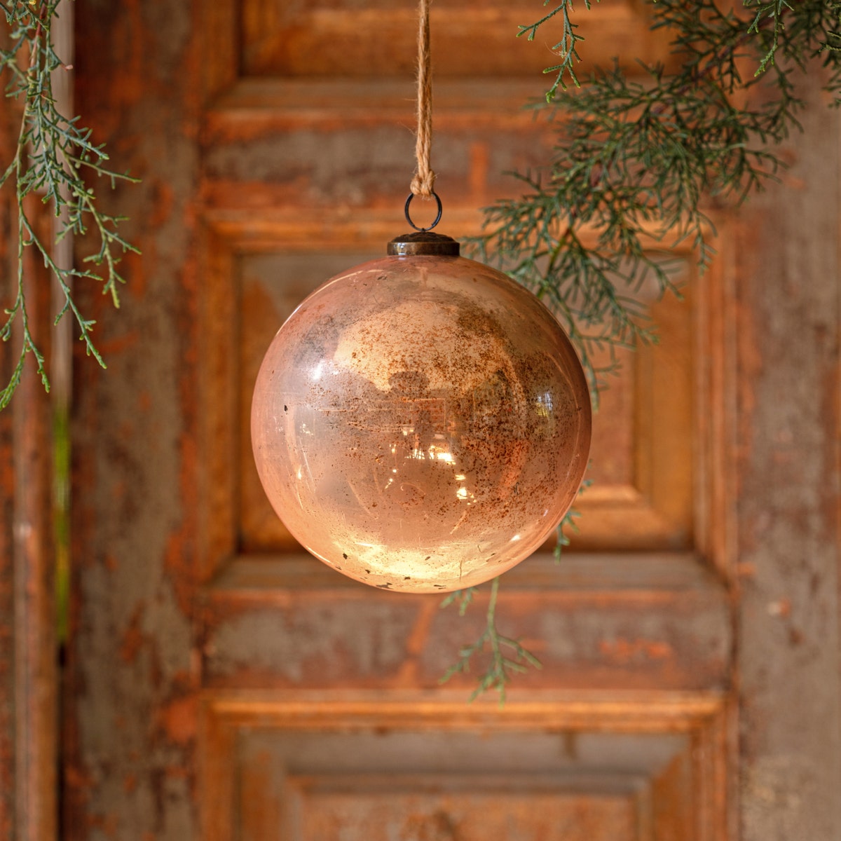 6-inch cameo antique finished glass ball ornament hanging from a twine string.
