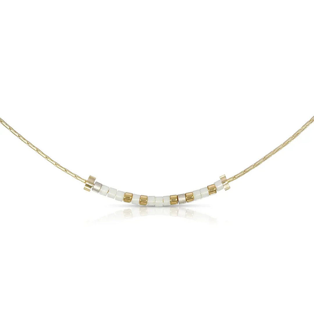 Bestie Morse code necklace with white and pewter glass beads on a gold chain.
