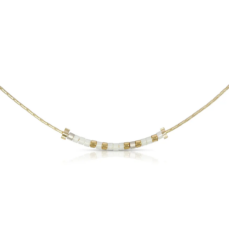 Bestie Morse code necklace with white and pewter glass beads on a gold chain.