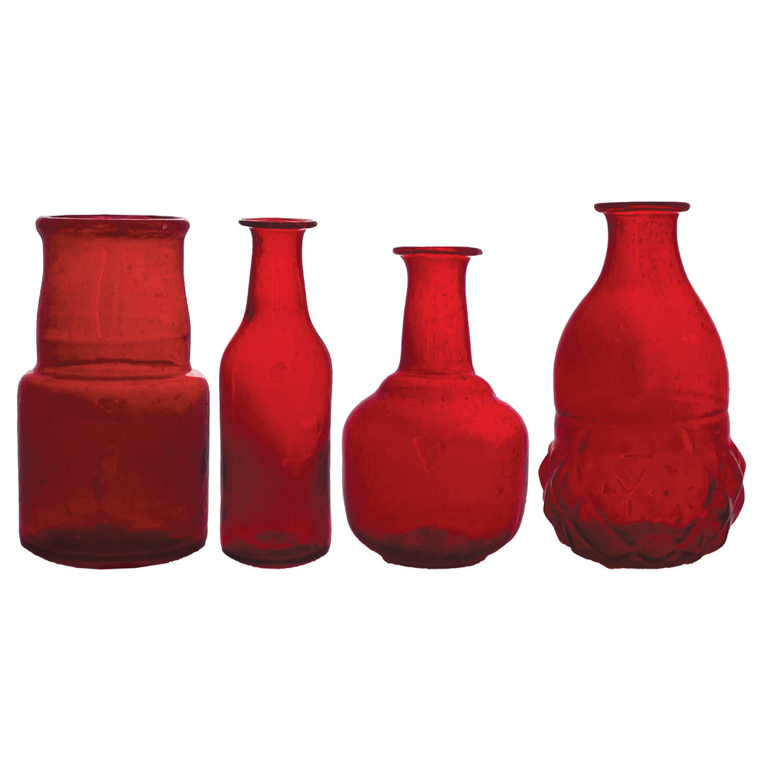 Four assorted hand-blown ruby red glass bud vases in various shapes and sizes.