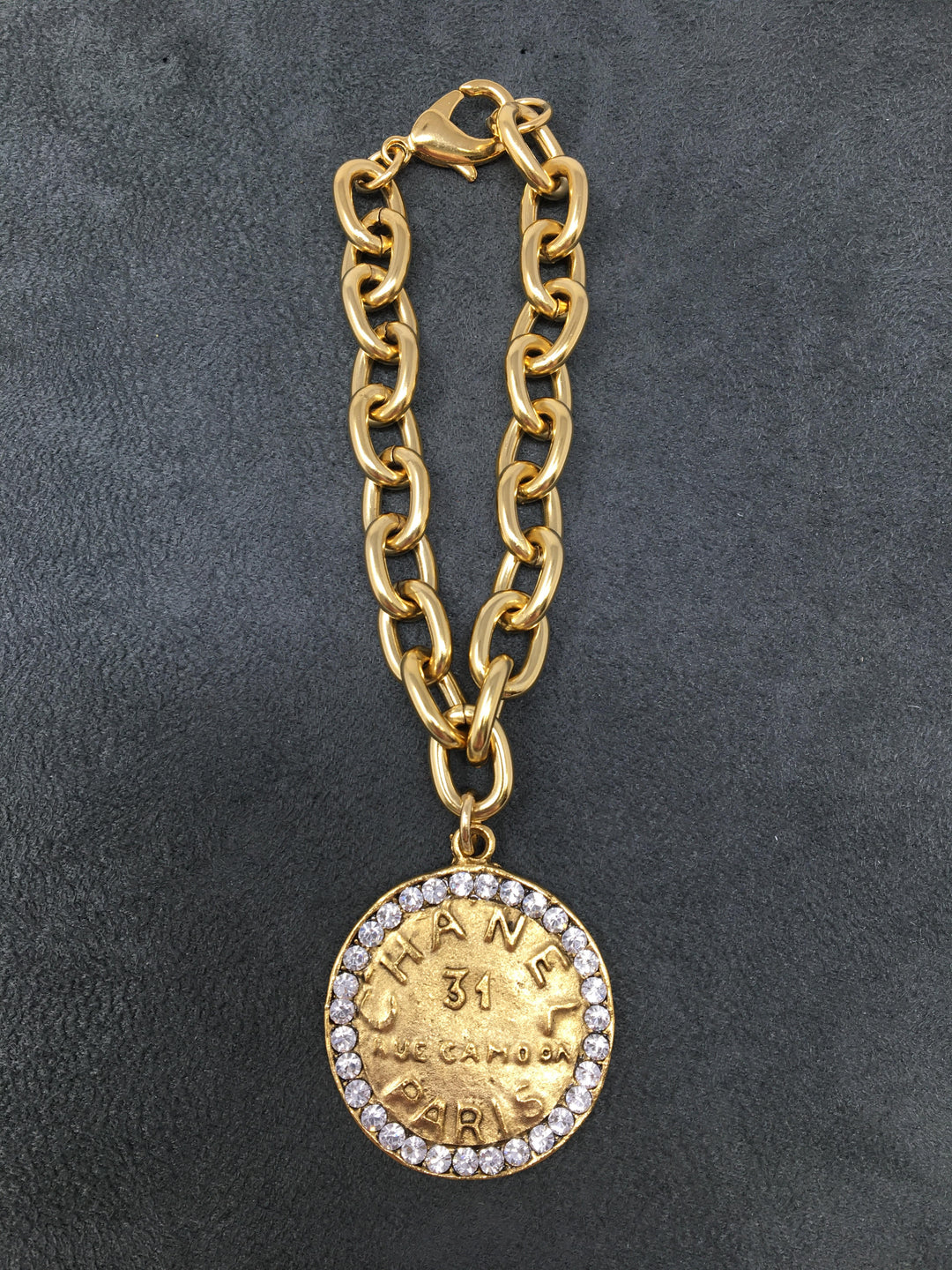 4-inch gold link bracelet featuring a Chanel-style coin pendant with rhinestones.