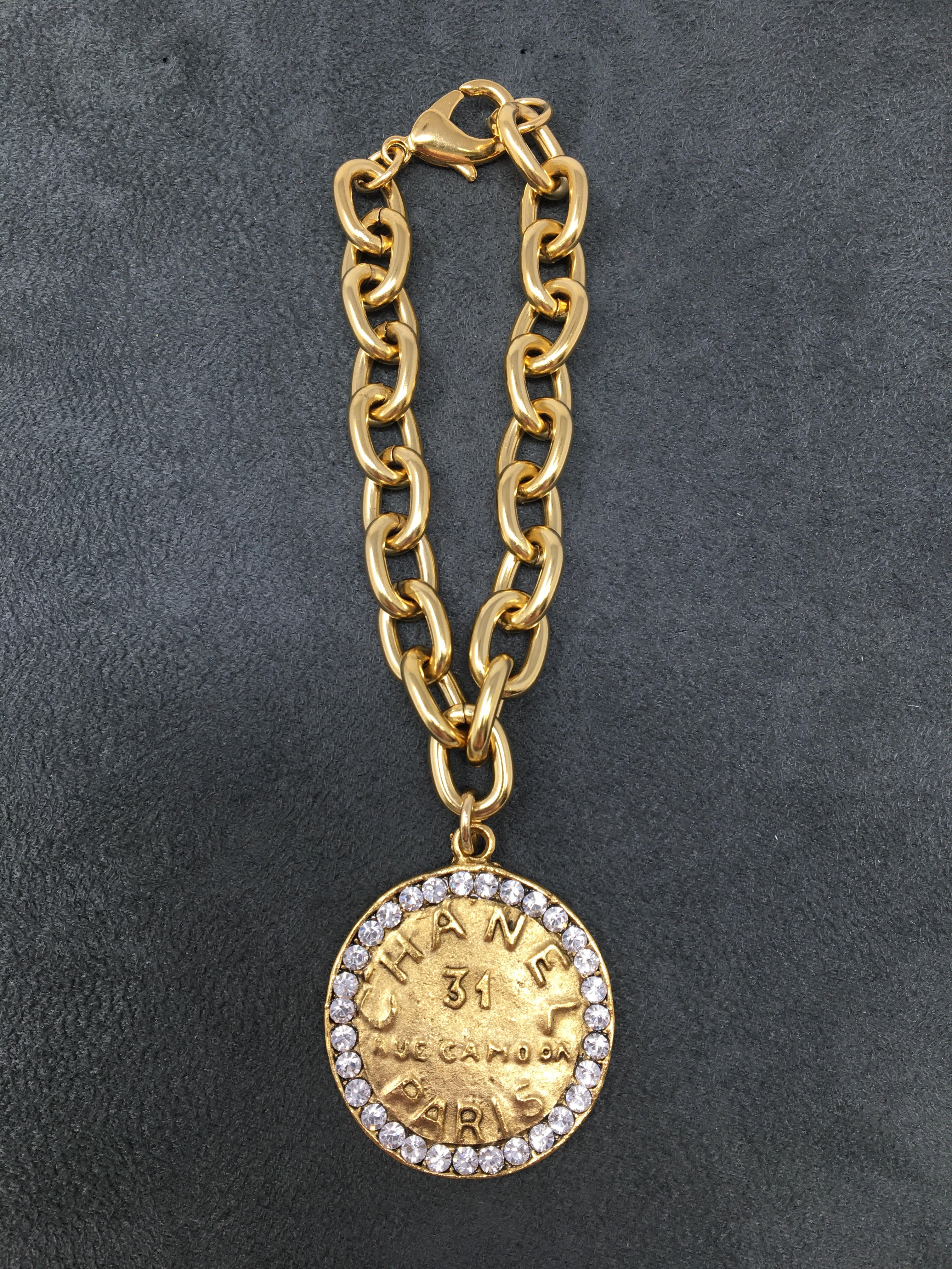 4-inch gold link bracelet featuring a Chanel-style coin pendant with rhinestones.