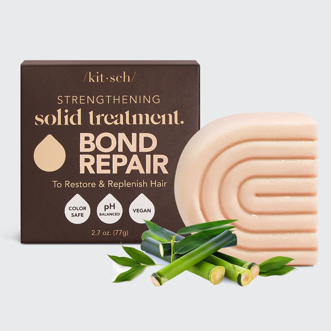 Kitsch Strengthening Bond Repair Solid Hair Mask bar next to its brown box and bamboo stalks.