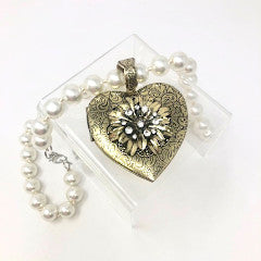 Fashion pearl necklace with an intricate heart-shaped pendant locket on a chain.