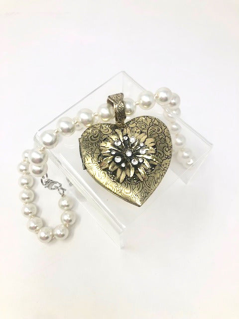 Fashion pearl necklace with an intricate gold-tone heart pendant locket featuring a floral design.