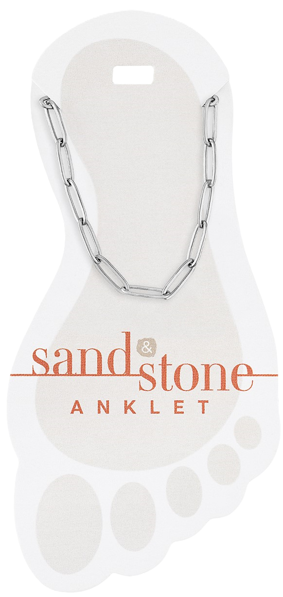 Silver paperclip chain anklet displayed on a white foot-shaped card with Sand & Stone branding.