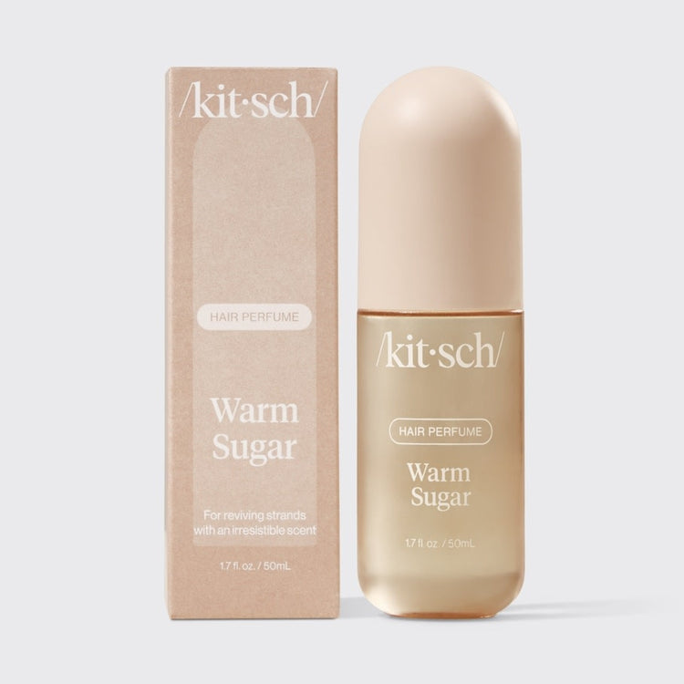 Small bottle of Warm Sugar Hair Perfume with a white cap against a neutral background.