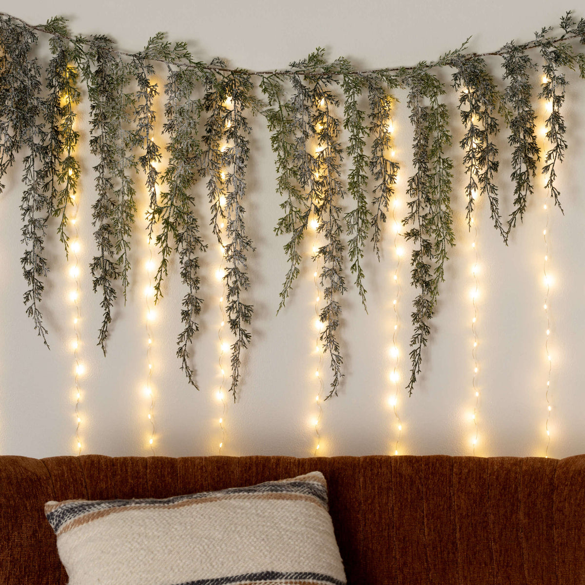 Metal curtain light with warm white LEDs draped over a window frame