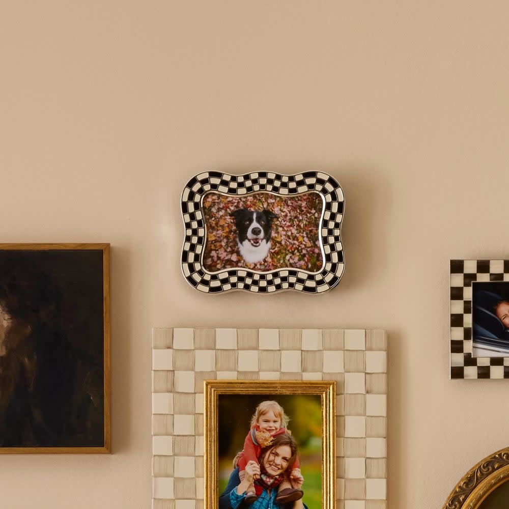 Silver-plated frame with wavy enamel check pattern, glass insert, velvet backing, and easel stand.
